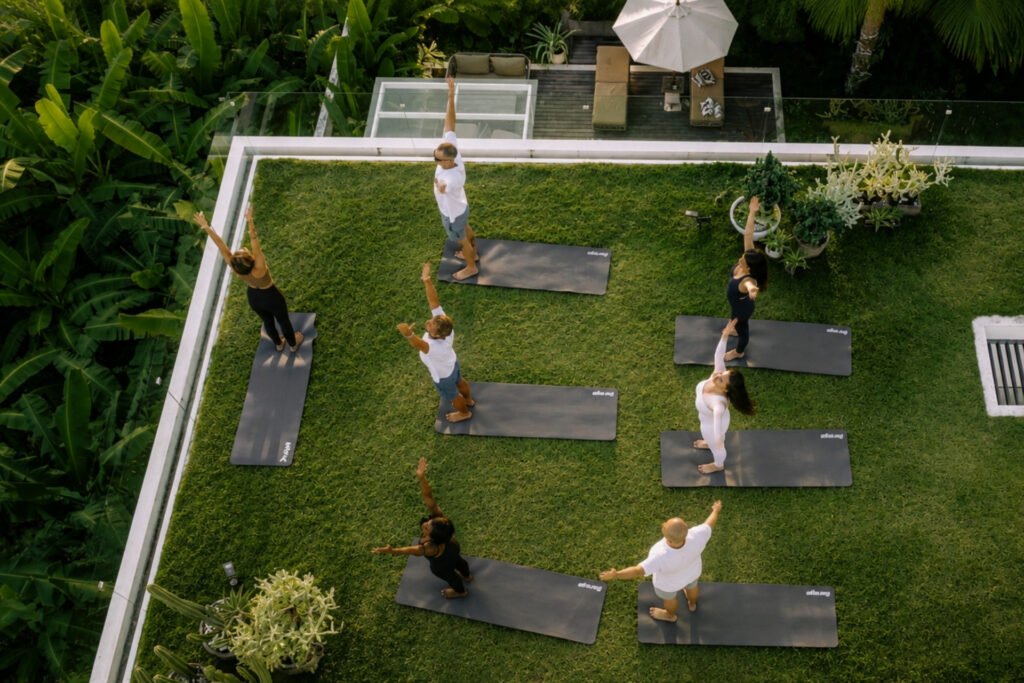 Small group taking part in a morning yoga session on the lawn of a residential treatment centre in Bali